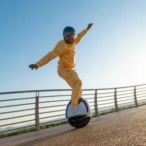 Man balancing on the Inmotion E20 electric unicycle by the seashore.