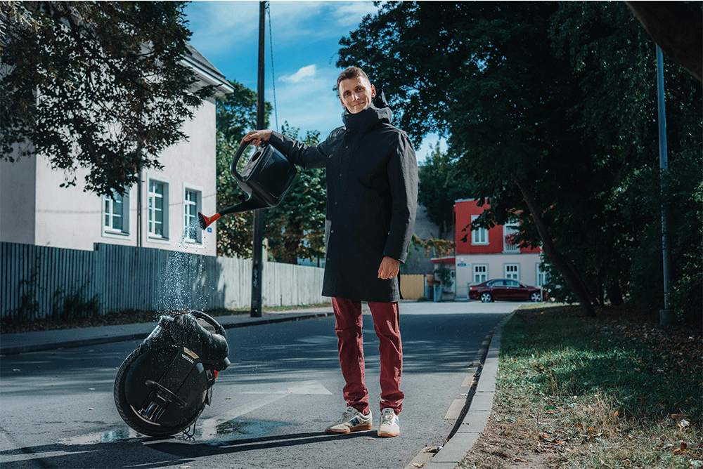 Man pouring water on the Inmotion V11 electric unicycle demonstrating the wheel's water resistance.