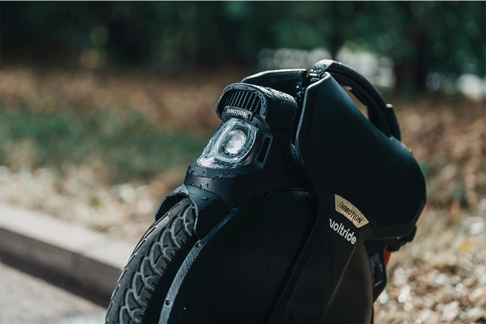 Close-up of the wet Inmotion V11 electric unicycle on a city street.