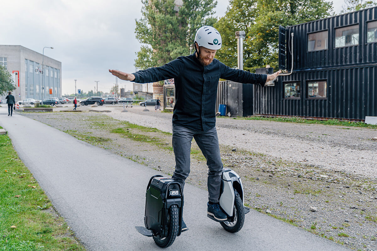 Voltride founder Mart Einpalu Voltride founder Mart Einpalu riding two electric unicycles simultaneously on a city street, demonstrating balance and control.
