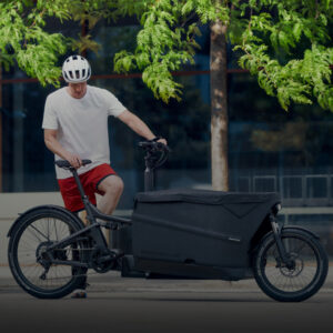 Man with a black Riese & Müller Packster cargo e-bike, ideal for family transport and urban deliveries