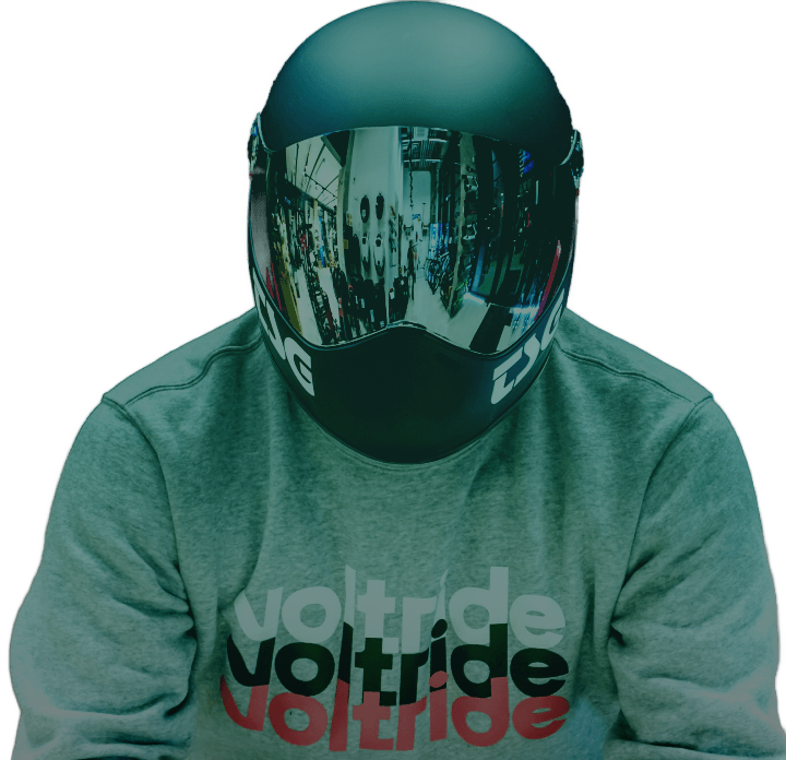 A man wearing a reflective helmet with a voltride shirt on.