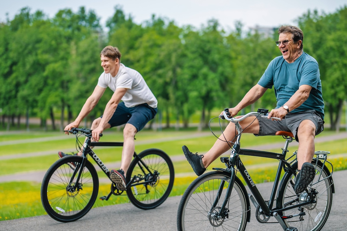 E-bike Oolter Torm black Oolter Eke blue with 2 men riding happy banner