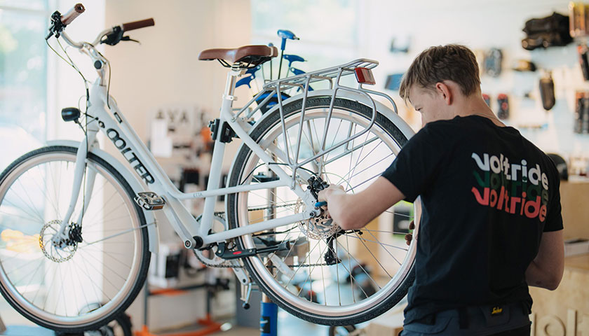 A banner showing a Voltride technician working on an electric bicycle
