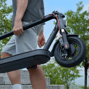 Man carrying folded Xiaomi electric scooter up outdoor stairs on a sunny day