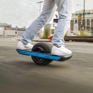 Closeup view of a man riding the Onewheel Pint X on the city street.