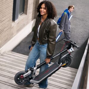 Girl carrying the folded Segway E3 Pro electric scooter up the stairs in the city.