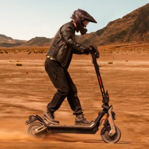 Man riding the Segway-Ninebot GT3 Pro electric scooter offroad wearing gloves and a full face helmet.