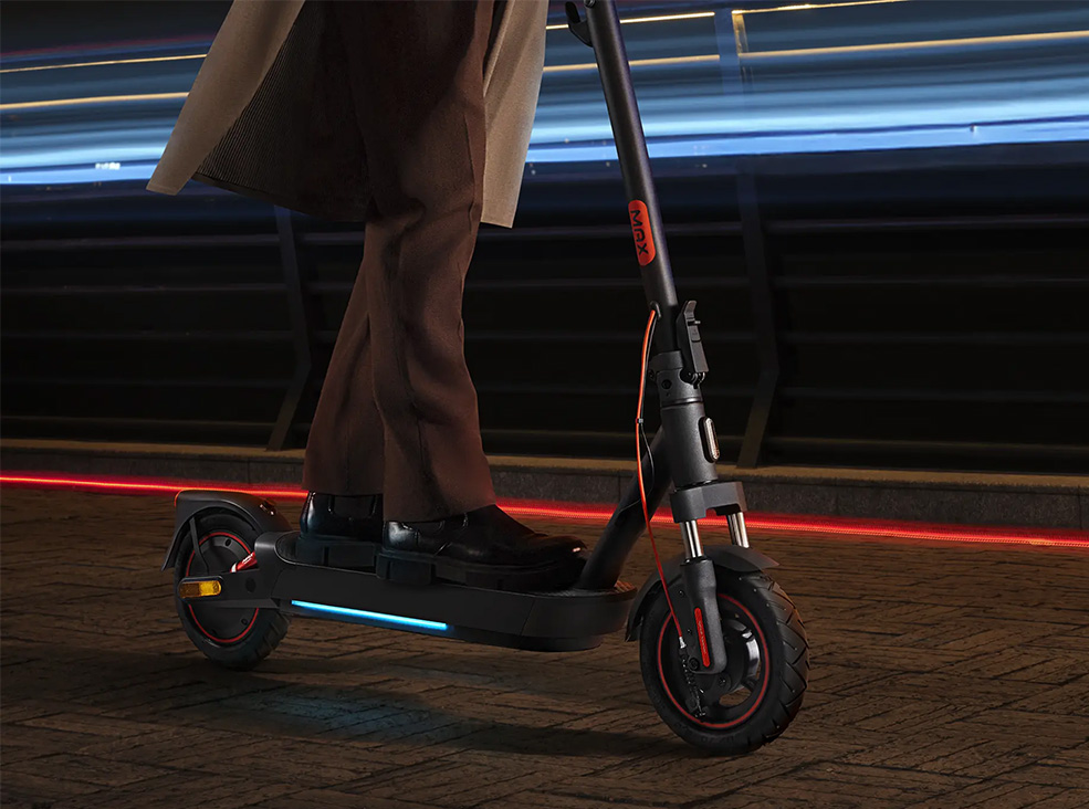 Xiaomi 5 Max ambient lights Person riding the Xiaomi 5 Max electric scooter during the night demonstrating the scooter's ambient light system.