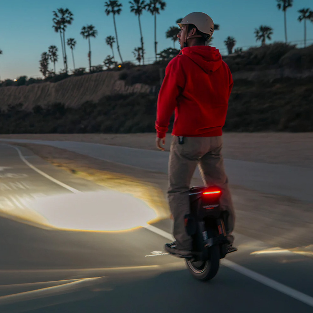Person riding the Inmotion V12S electric unicycle demonstrating the front light.