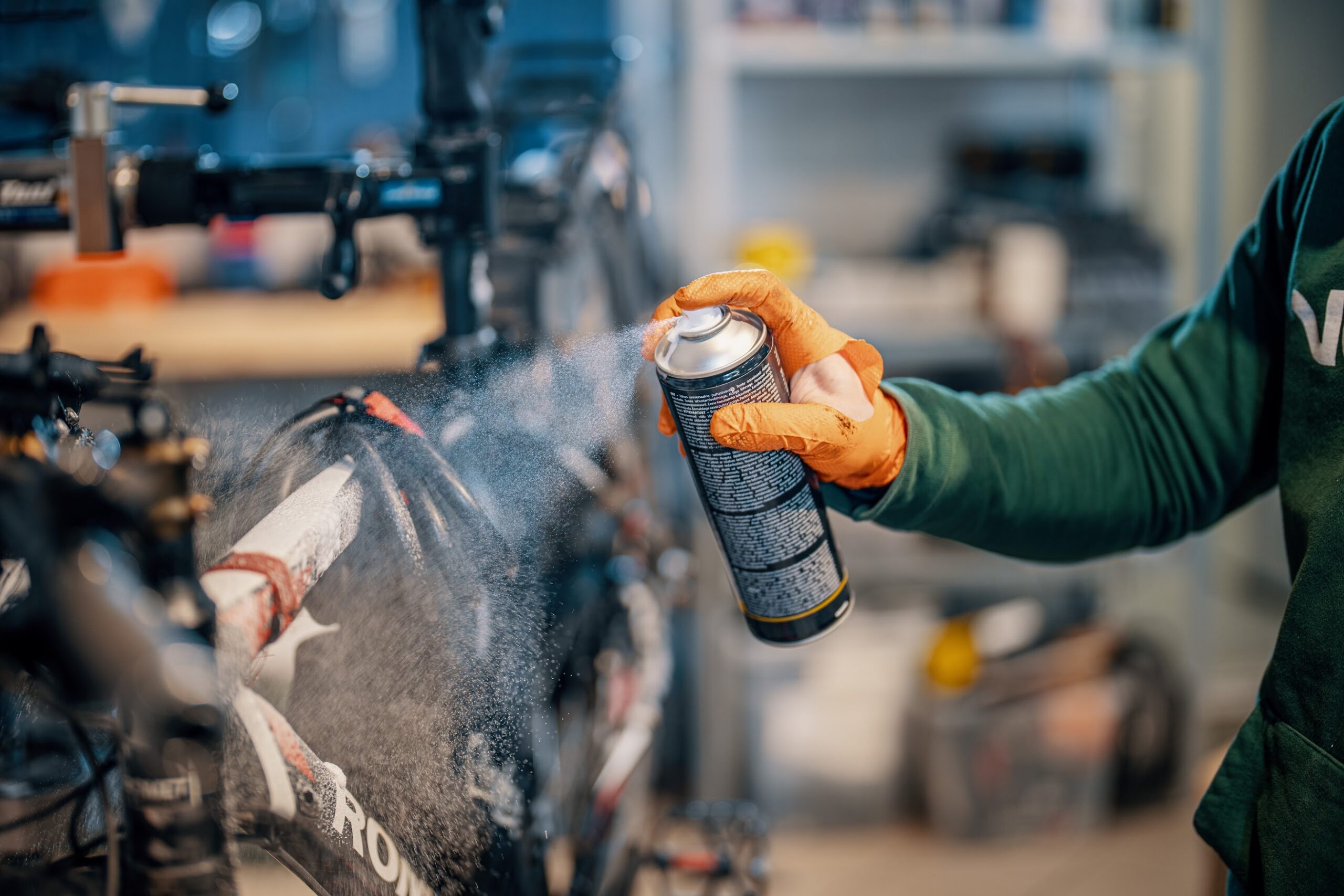 Close-up of bike cleaning process with spray applied to frame and components